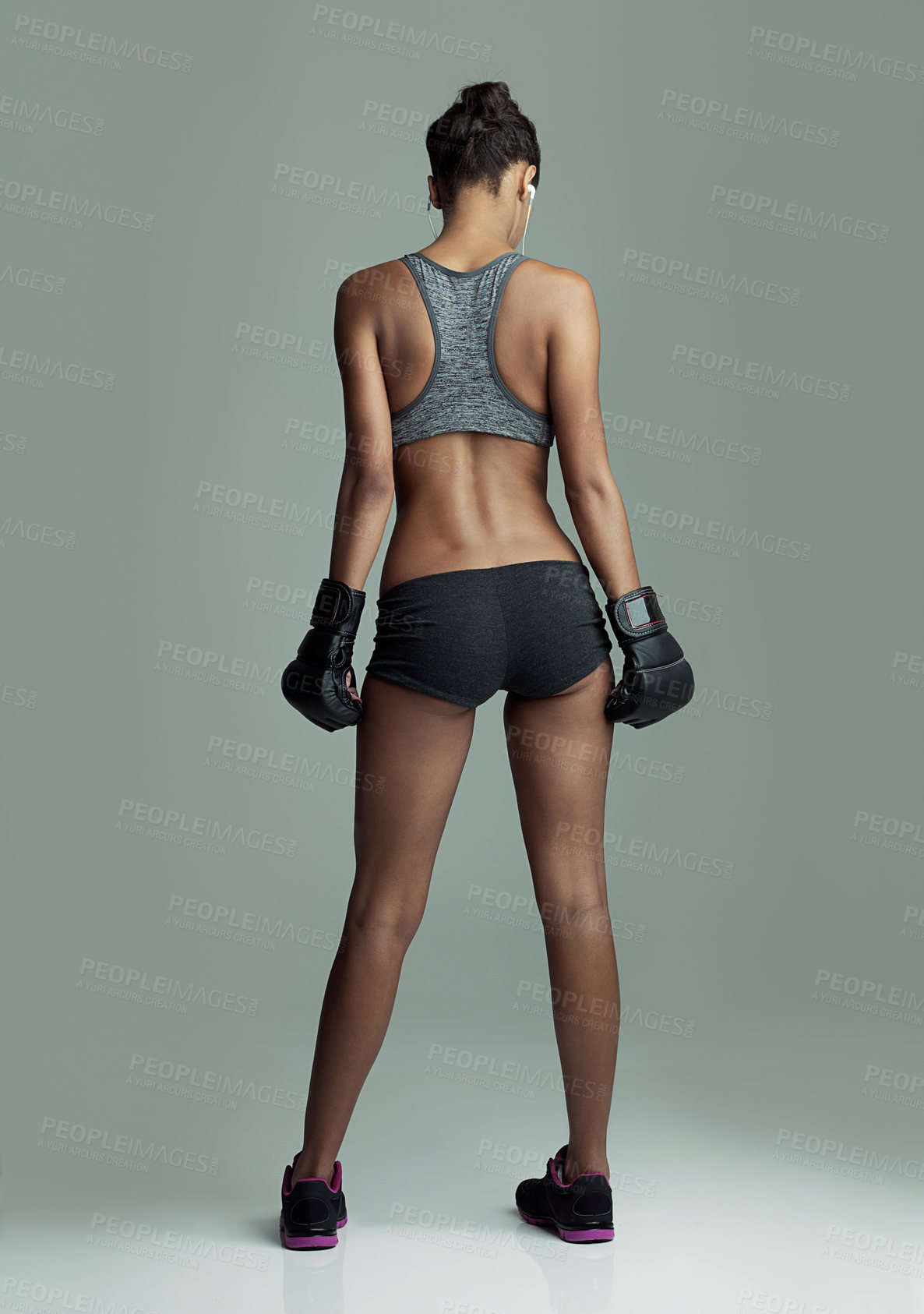 Buy stock photo Rearview studio shot of a fit young boxer against a gray background