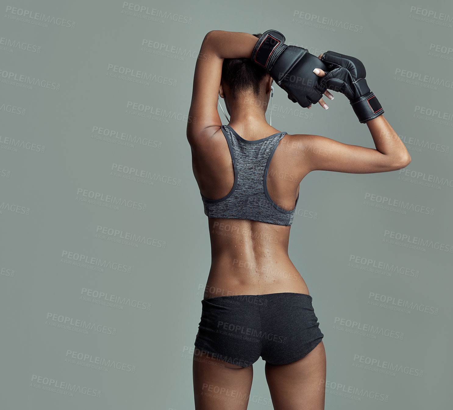 Buy stock photo Fitness, back and female boxer in studio for sport, ready and training on gray background. Workout, woman and stretching for exercise with sportswear, boxing gloves and earphones for determination