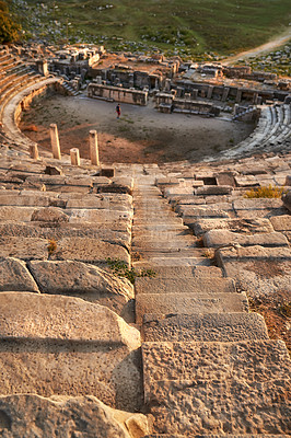 Buy stock photo Landscape, amphitheater and ancient architecture with stone, outdoor and city for tourism landmark. Building, ruins or stadium in nature with culture, heritage and person in Bodrum, Turkey.