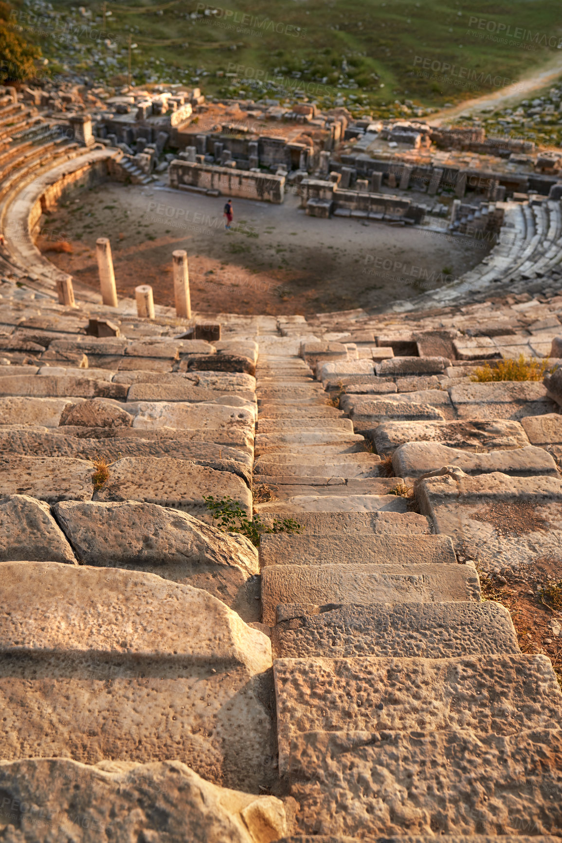 Buy stock photo Landscape, amphitheater and ancient architecture with stone, outdoor and city for tourism landmark. Building, ruins or stadium in nature with culture, heritage and person in Bodrum, Turkey.