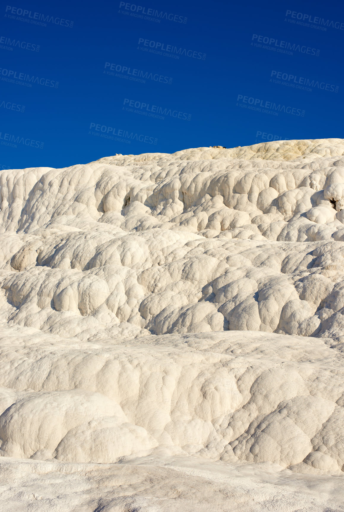 Buy stock photo The Travertine pools and terraces in Pamukkale, Turkey. Desert sand with curvy pattern texture against a blue sky. Tourism holiday destination at rock cotton castle location during hot springs