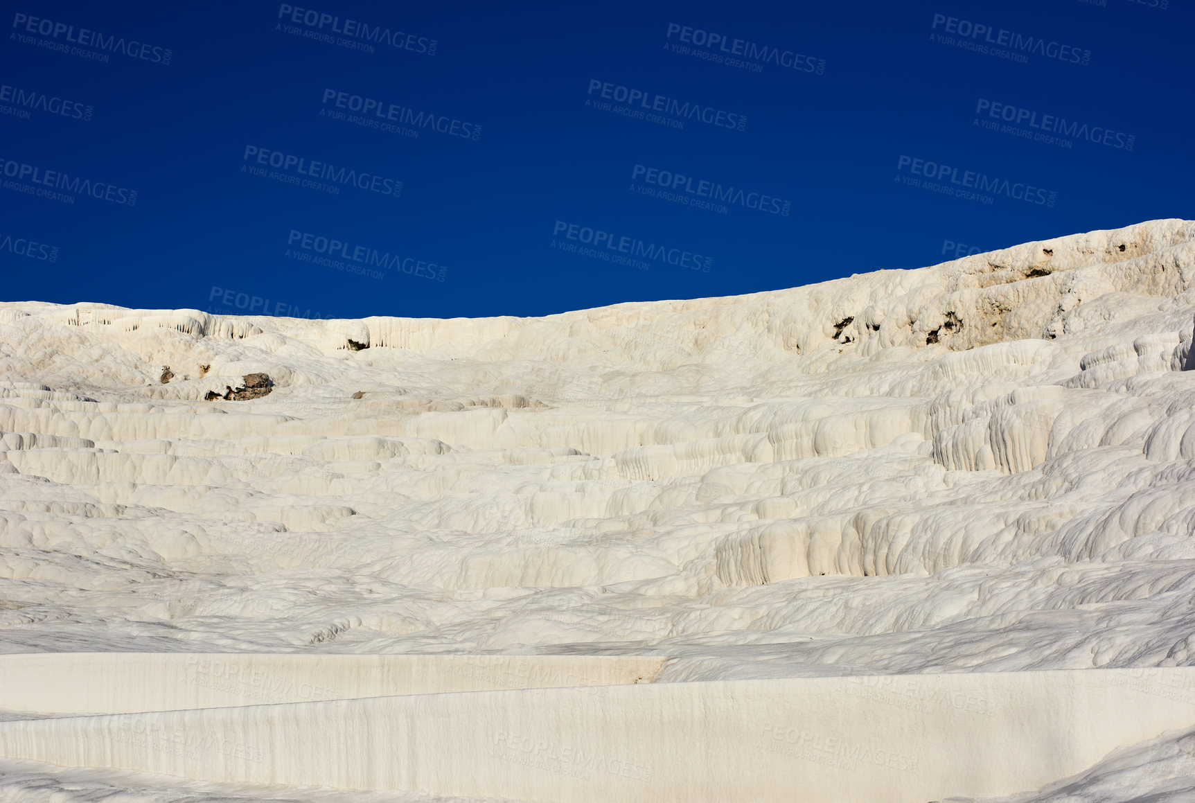 Buy stock photo Landscape of the Travertine terraces in Pamukkale, Turkey. Desert sand with curvy pattern texture against a blue sky. Tourism holiday destination at rock cotton castle location during hot springs