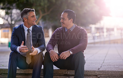 Buy stock photo Shot of two businessmen having a discussion while sitting outside