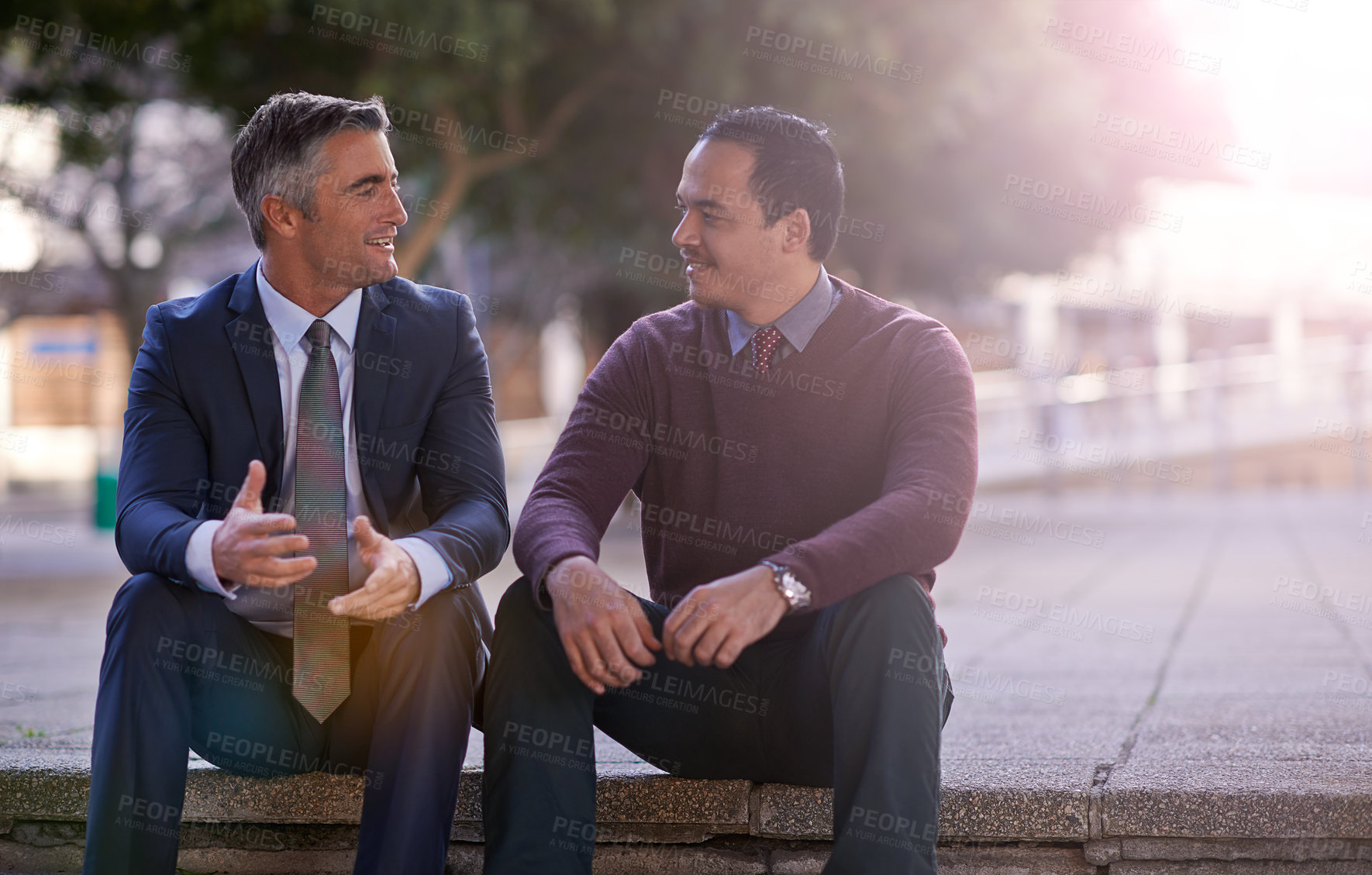 Buy stock photo Shot of two businessmen having a discussion while sitting outside
