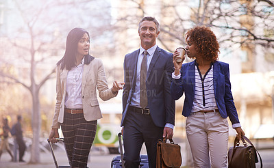 Buy stock photo Shot of a group of businesspeople walking together in the city