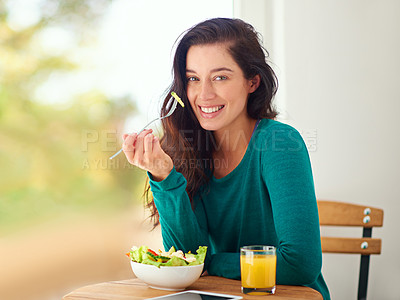 Buy stock photo Portrait of a young woman eating a healthy salad at home