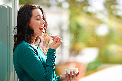 Buy stock photo Shot of a young woman eating a healthy snack at home