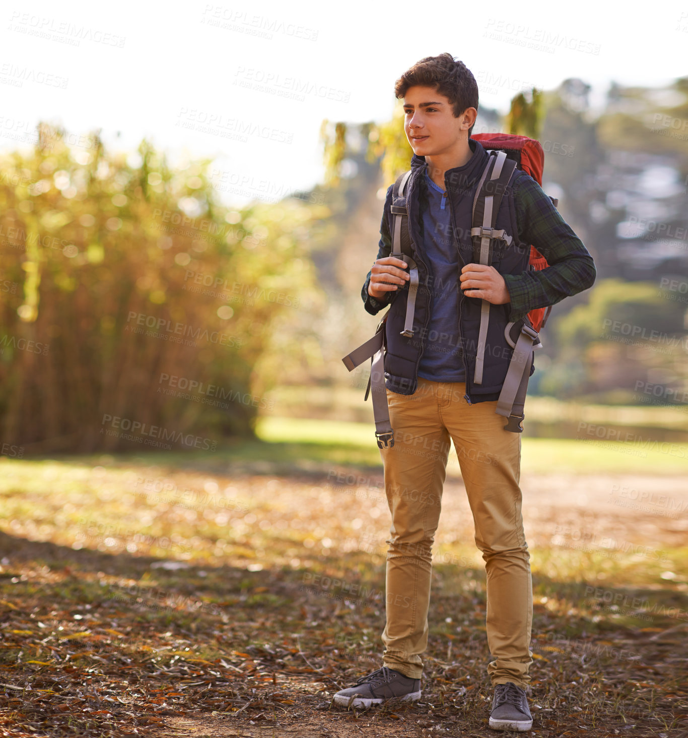 Buy stock photo Shot of a young boy wearing a backpack in nature