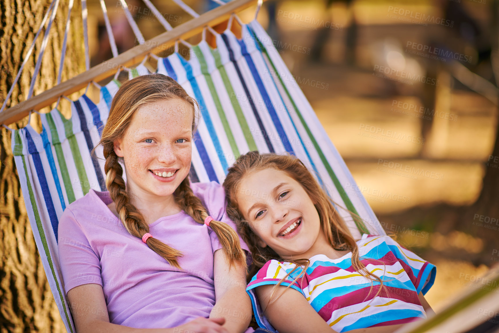 Buy stock photo Shot of a two young girls relaxing in a hammock