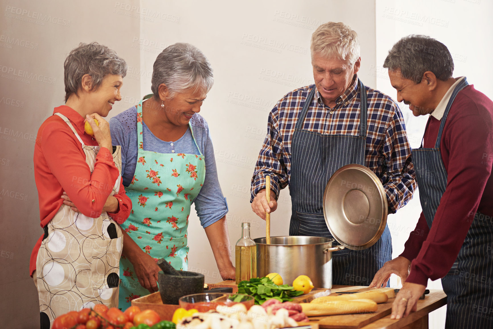 Buy stock photo Shot of a group of seniors cooking in the kitchen