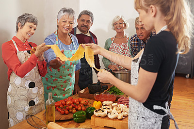 Buy stock photo Cooking, pasta class and woman with people in kitchen learning recipe for cuisine, culinary and chef skills. Retirement, teacher and and men and women with ingredients, dough and food for dinner