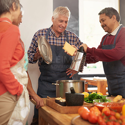 Buy stock photo Shot of a group of seniors cooking in the kitchen