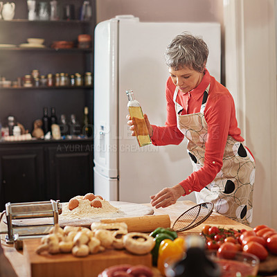 Buy stock photo Food, cooking and senior woman in kitchen with olive oil, egg or flour for meal prep, fun or hobby with fresh ingredients at home. Nutrition, wheat or elderly lady with traditional Italian pasta dish