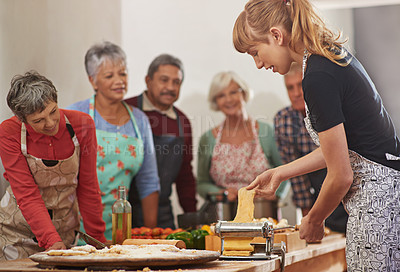 Buy stock photo Food, senior cooking class and a woman teaching people in the kitchen of a home for meal preparation. Pasta maker, equipment and learning with mature friends watching a female chef follow a recipe