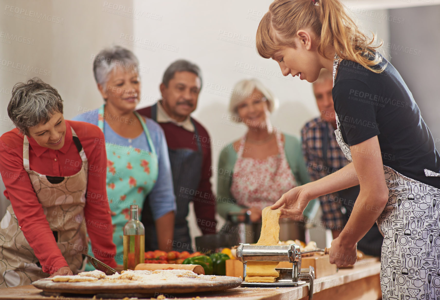 Buy stock photo Food, senior cooking class and a woman teaching people in the kitchen of a home for meal preparation. Pasta maker, equipment and learning with mature friends watching a female chef follow a recipe
