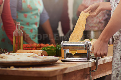 Buy stock photo Food, fresh pasta with hands of woman at kitchen counter and with people in family restaurant. Cooking or bakery, rolling pin and female person with pastry machine preparing pizza or cooking dough