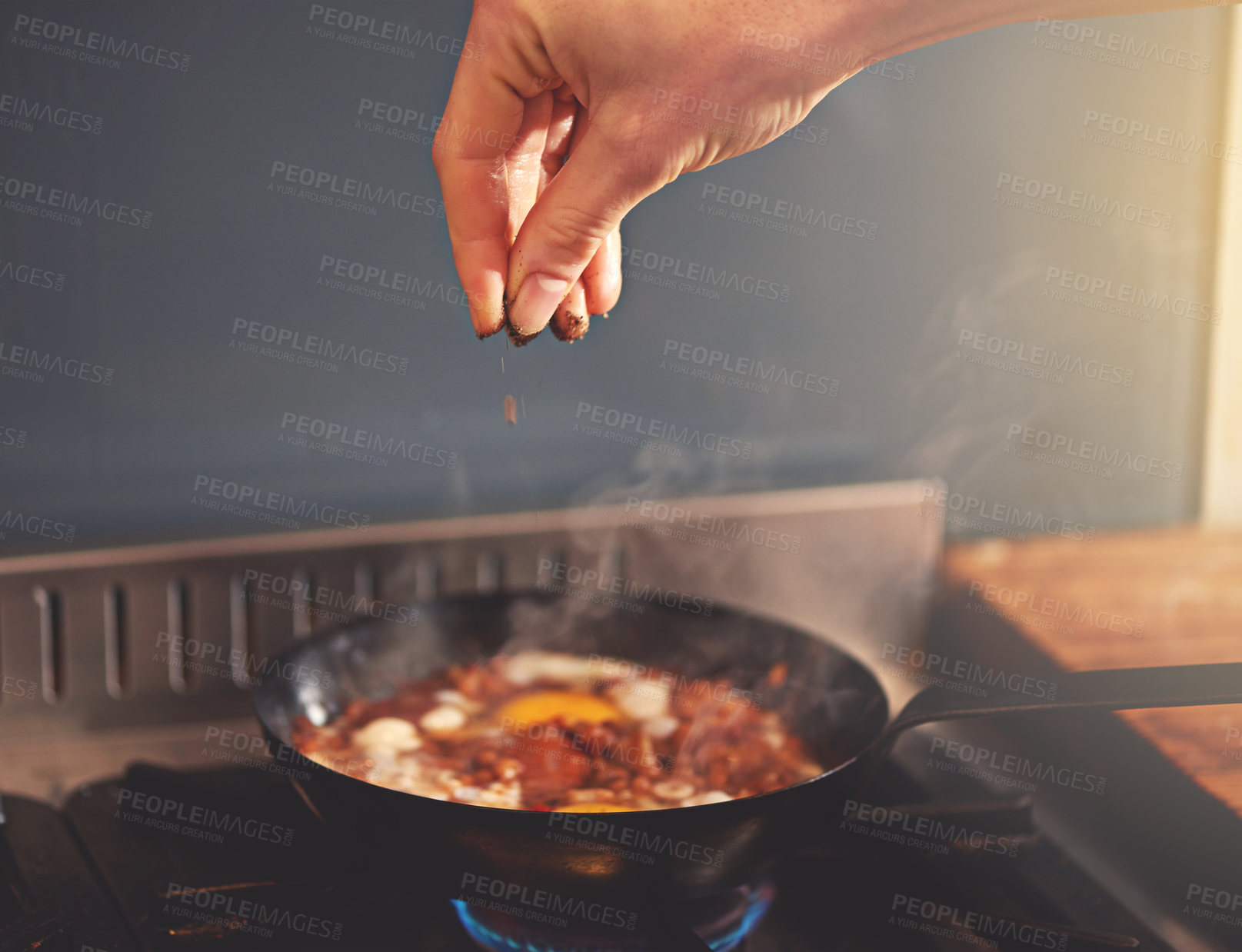 Buy stock photo Cropped shot of a person seasoning a dish on the stove