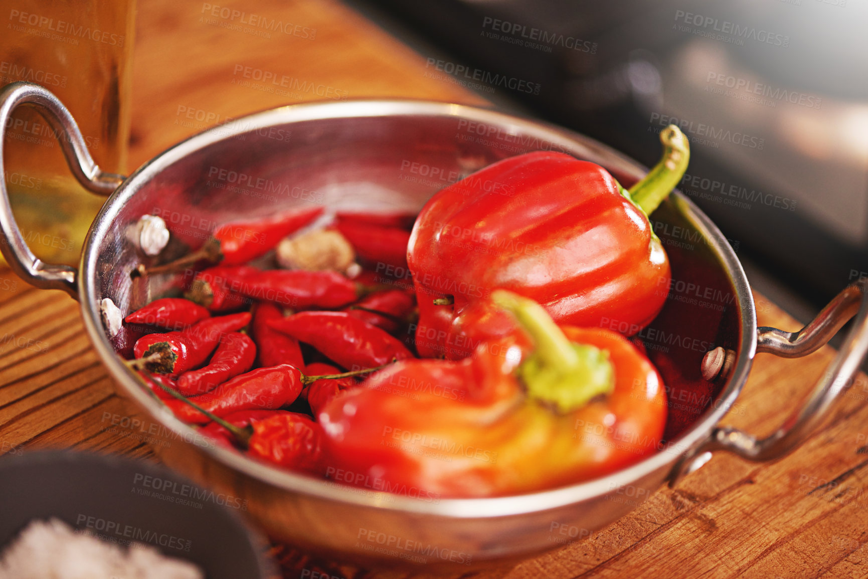 Buy stock photo Shot of a pan filled with red peppers and chillies on a tabletop