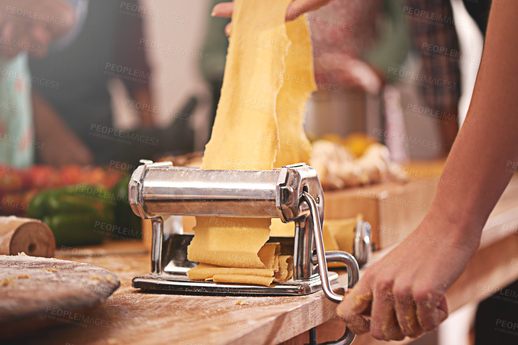 Buy stock photo Cropped shot of a person rolling freshly made dough through a pasta maker