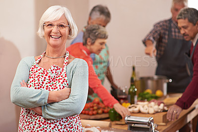 Buy stock photo Portrait of a senior woman with friends cooking together in the background