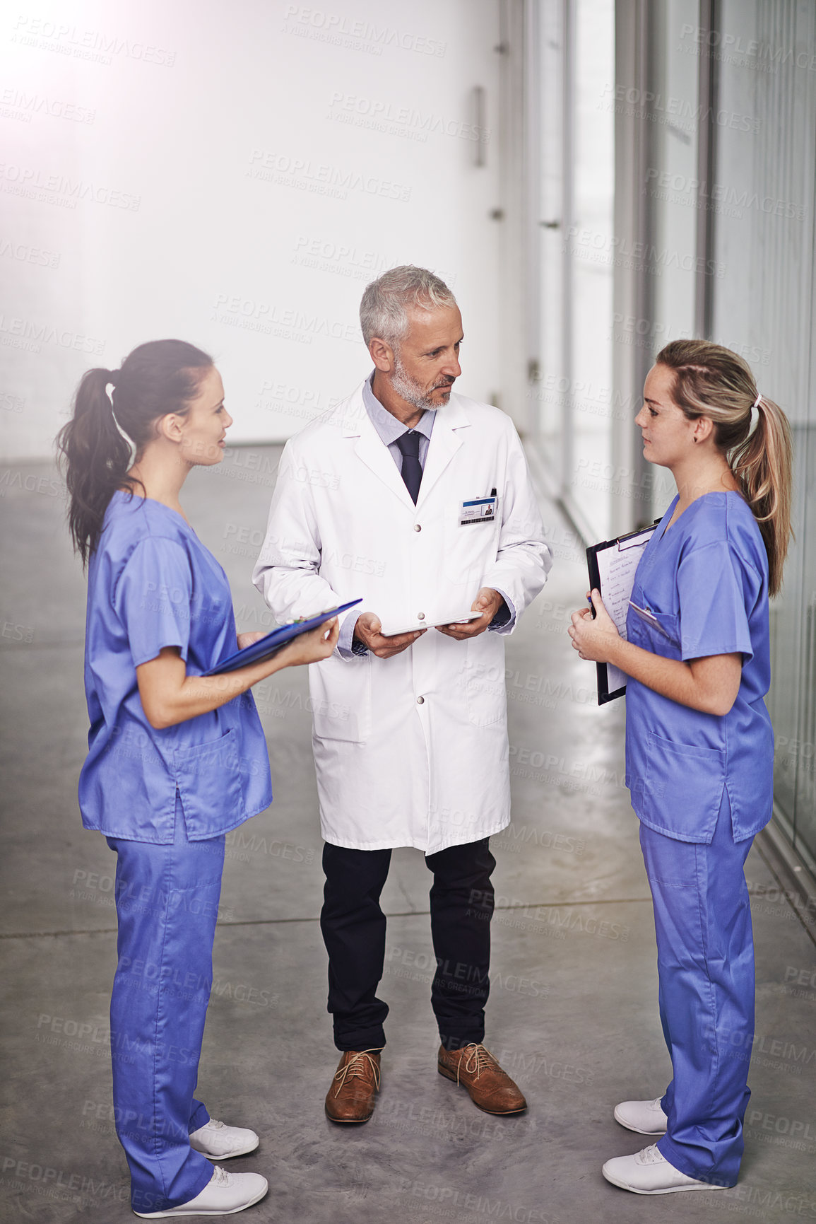 Buy stock photo Doctor, man and woman with tablet for internship, advice and teaching in hospital hallway. People, mature medic and mentorship for healthcare service with checklist, notes and information in clinic