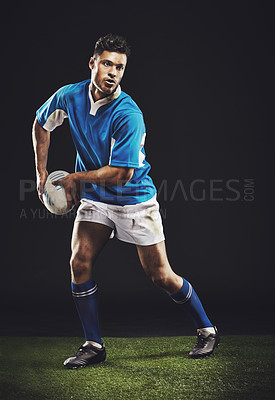 Buy stock photo Rugby, passing and man athlete running in dark studio background while training, wellness and fitness sport. Exercise, workout and professional career of sports male person or player on grass