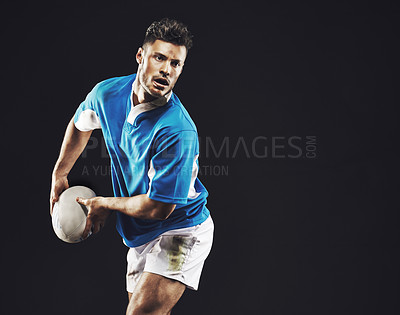Buy stock photo Studio shot of a rugby player passing the ball against a black background