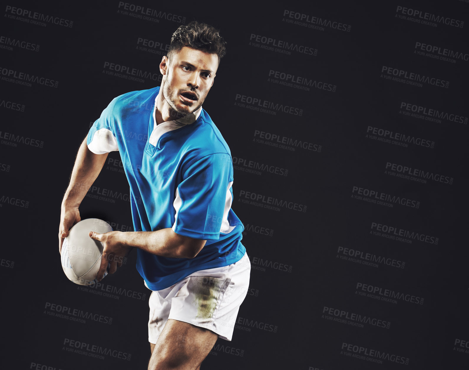 Buy stock photo Studio shot of a rugby player passing the ball against a black background