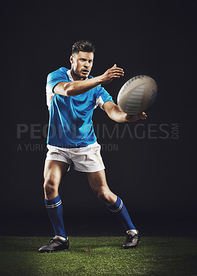 Buy stock photo Night, man and pass ball for rugby sports goal or training for skill for football game or match, professional and athlete. Male person or player, action and energy for competition and fitness workout
