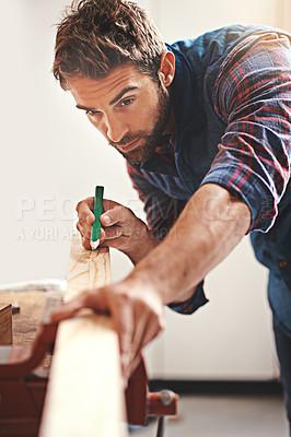 Buy stock photo Cropped shot of a carpenter making measurements on a plank of wood