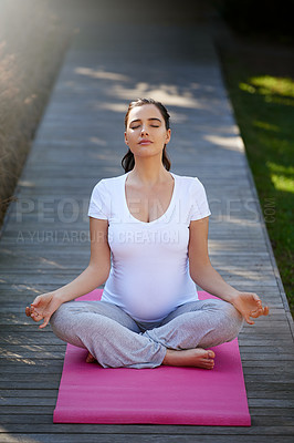 Buy stock photo Shot of a young pregnant woman doing yoga outside