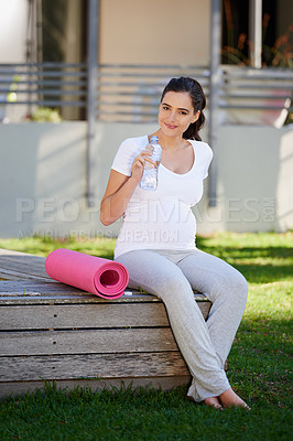 Buy stock photo Shot of a young pregnant woman sitting with her yoga mat outside
