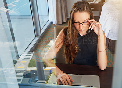 Buy stock photo A young businesswoman working on her laptop in her hotel room