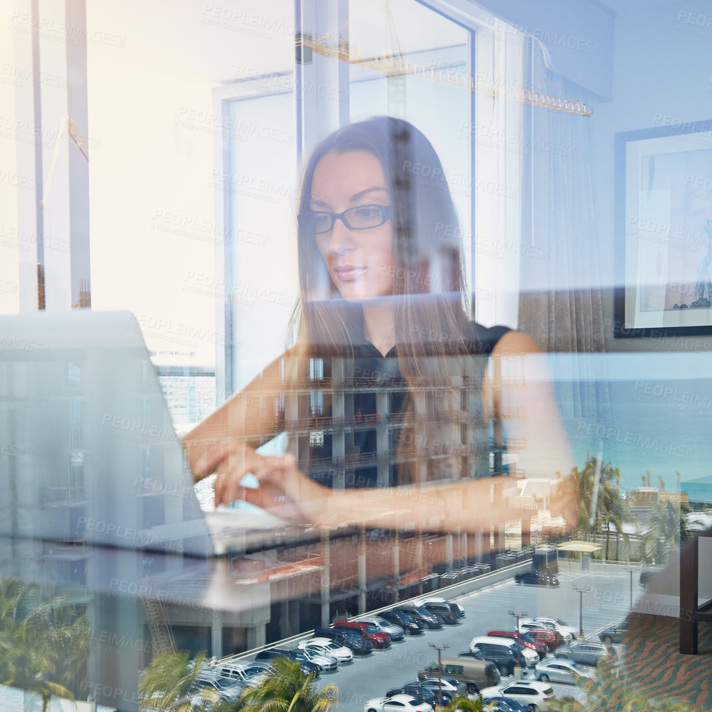 Buy stock photo A young businesswoman working on her laptop in her hotel room