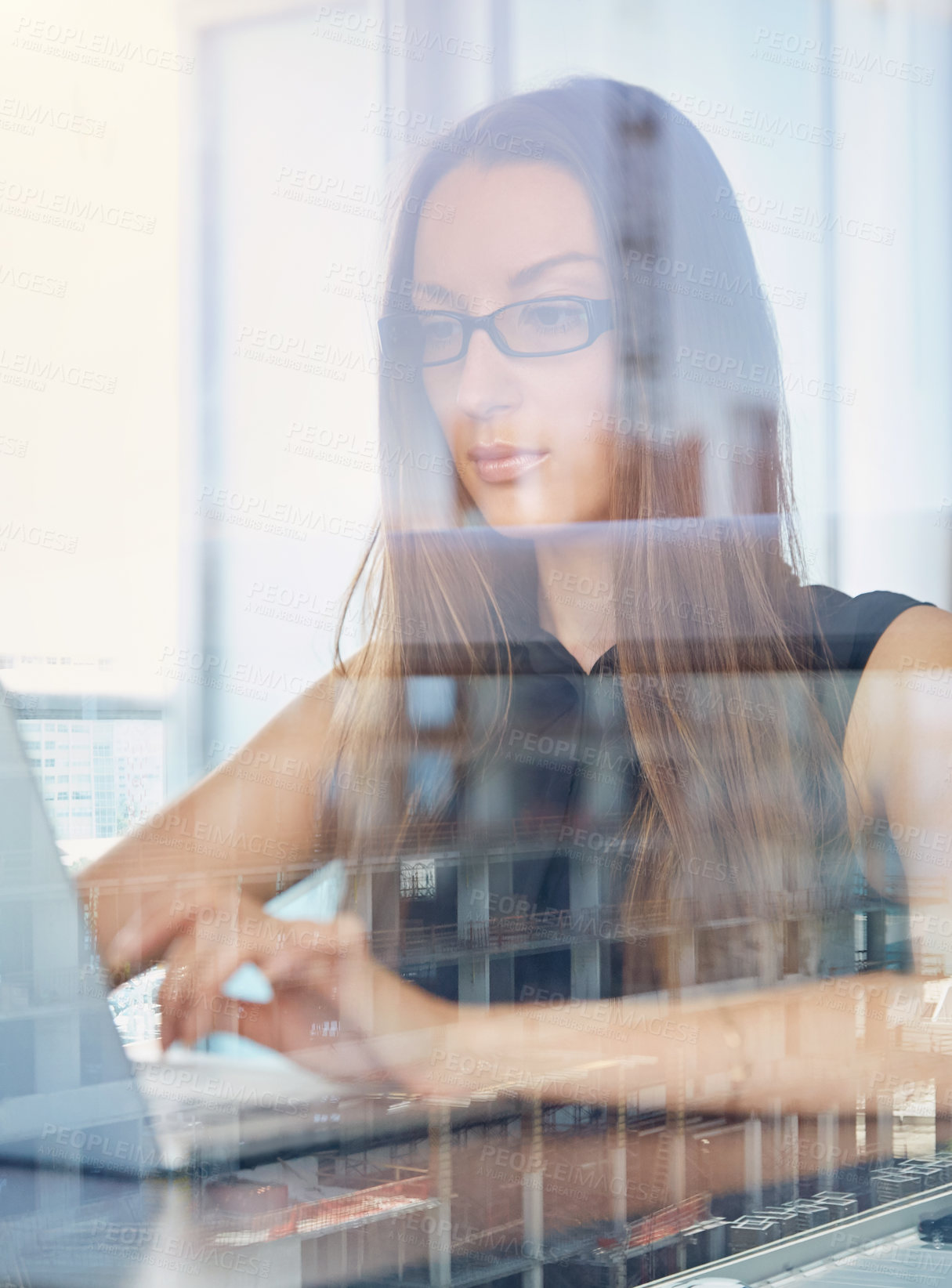 Buy stock photo A young businesswoman working on her laptop in her hotel room