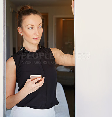 Buy stock photo Shot of a young woman using her cellphone in her hotel room