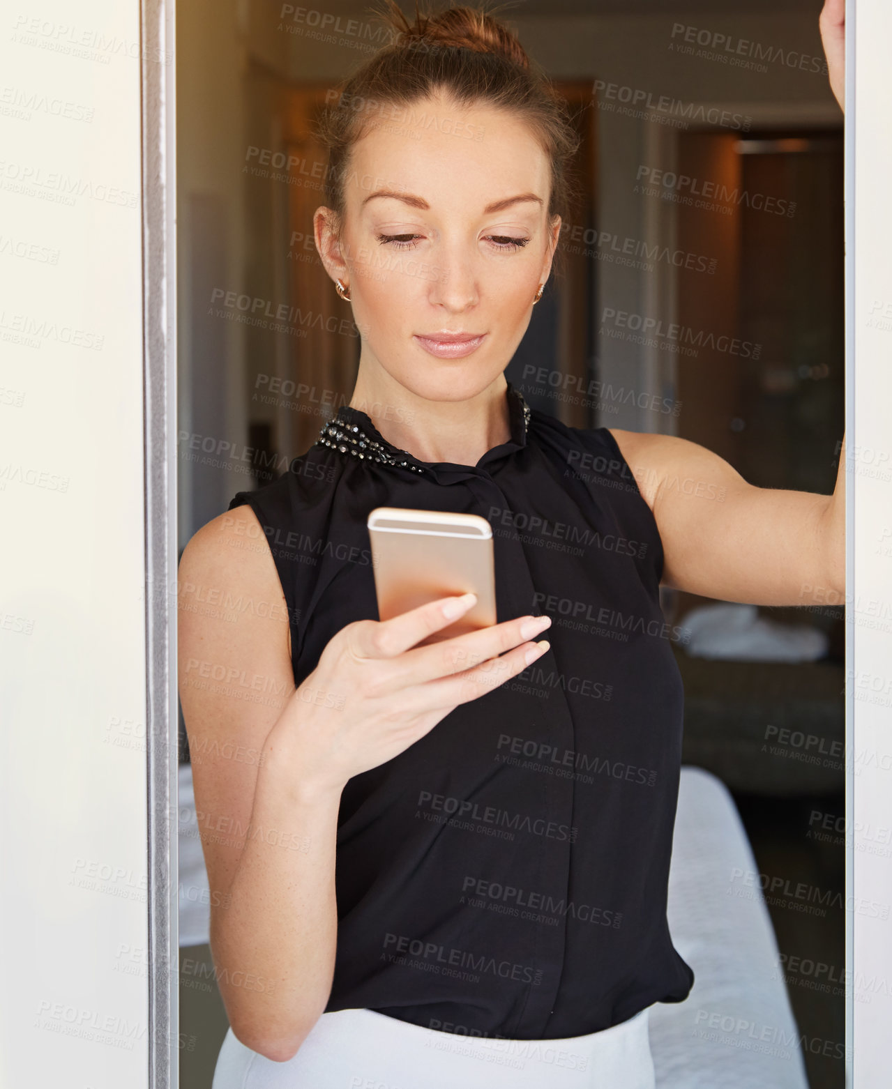 Buy stock photo Shot of a young woman using her cellphone in her hotel room