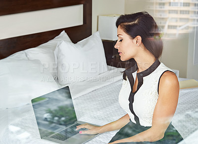 Buy stock photo Shot of a young businesswoman working in her hotel room