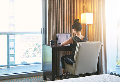 Buy stock photo Shot of a young businesswoman working in her hotel room