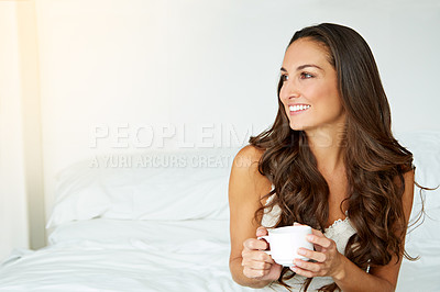 Buy stock photo Shot of a young woman drinking a coffee on her bed