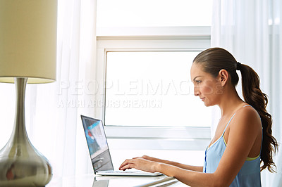 Buy stock photo Shot of a young woman using a laptop at home