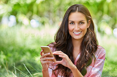 Buy stock photo Cropped portrait of an attractive young woman sending a text while sitting in her garden