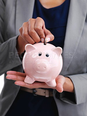 Buy stock photo Cropped shot of a businesswoman putting a coin into her piggybank