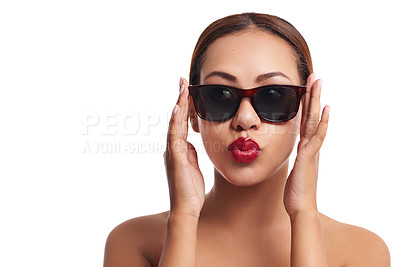 Buy stock photo Studio portrait of a young woman wearing sunglasses posing against a white background
