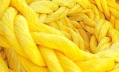 Buy stock photo Strong thick braided colorful rope woven and twined. Yellow thick rope macro closeup laying in a heap. Long twisted strong material symbolizes unity, togetherness, and teamwork