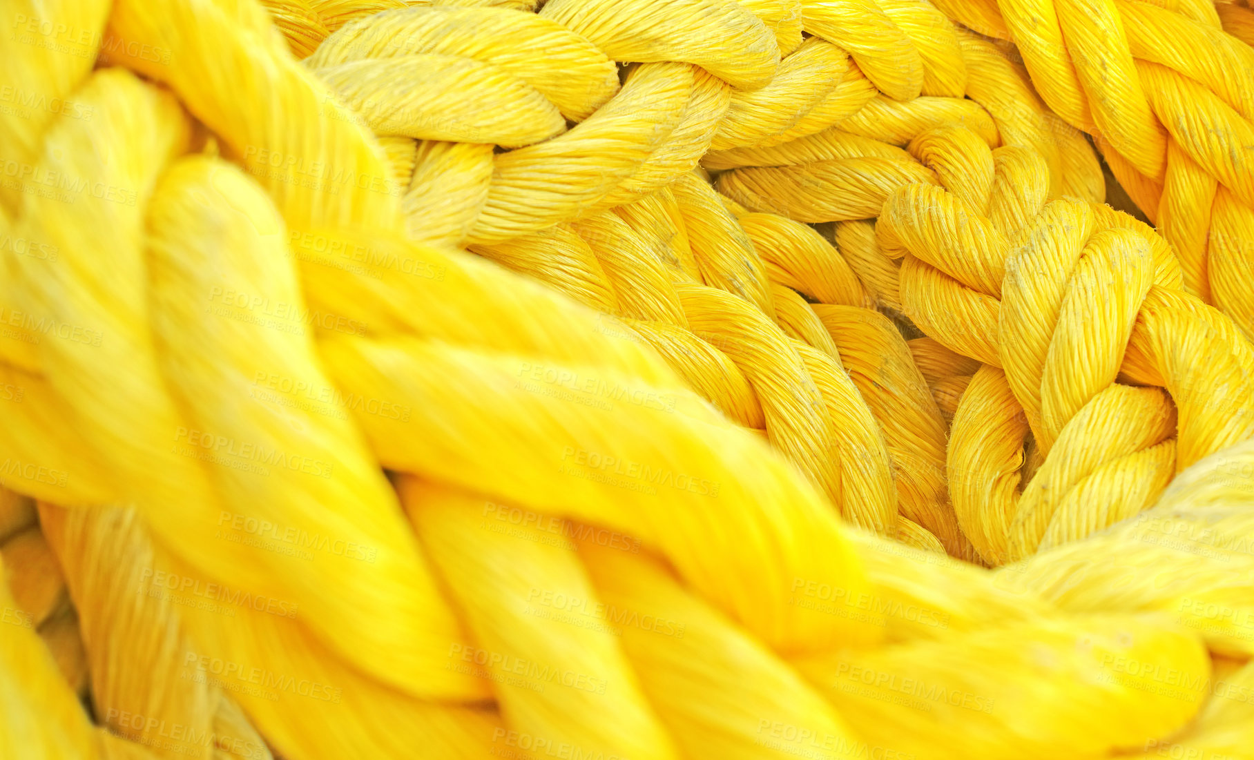 Buy stock photo Strong thick braided colorful rope woven and twined. Yellow thick rope macro closeup laying in a heap. Long twisted strong material symbolizes unity, togetherness, and teamwork