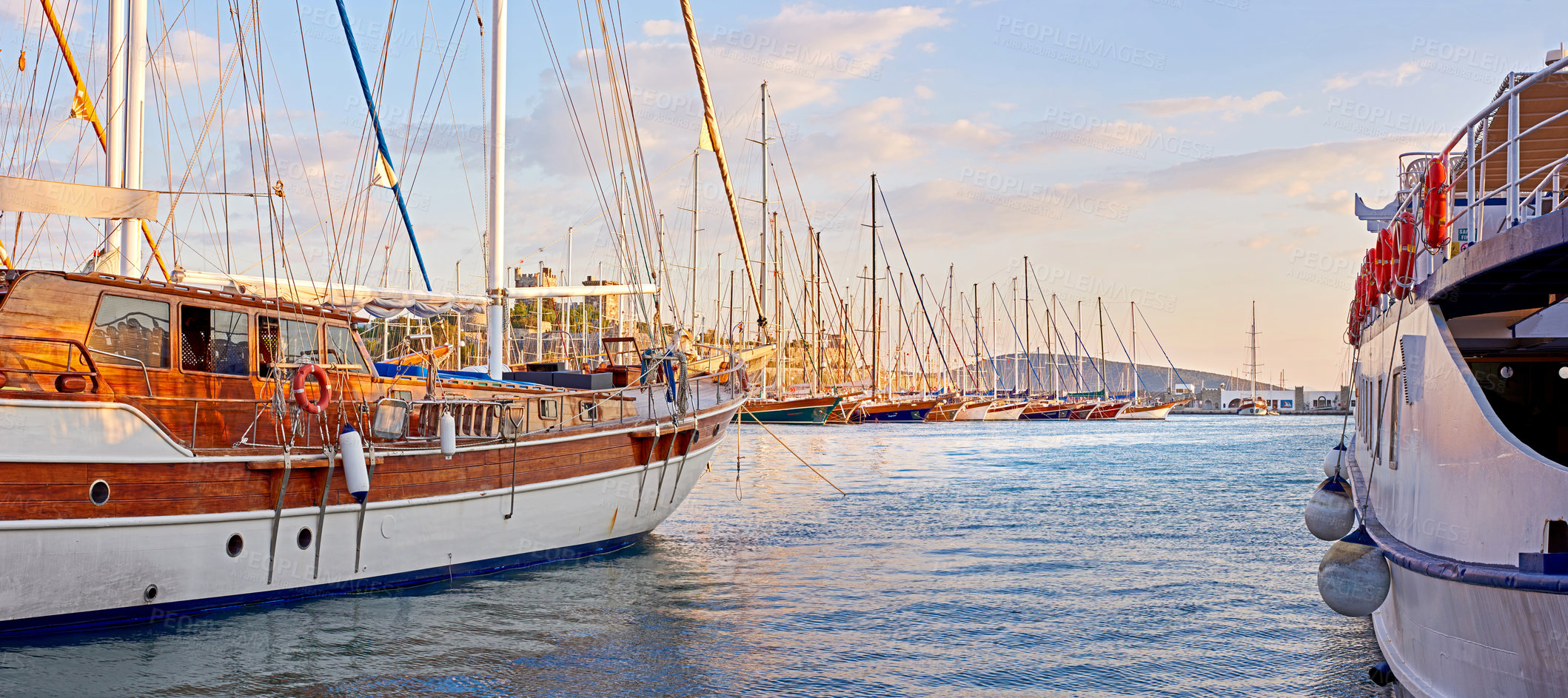 Buy stock photo The marine harbor of Bodrum, Turkey. Scenic view of expensive yachts moored in Milta Marina. Closeup of boats and yachts docked at a port or pier during sunset on the water during a warm summer day