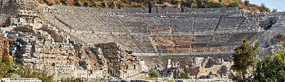 Buy stock photo Ancient amphitheatre ruins in the city of Ephesus, Turkey. Traveling abroad or overseas for holiday, vacation and tourism. Excavated remains of historical building stone from Turkish history