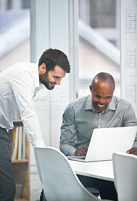 Buy stock photo Shot of two businesspeople sharing a laugh about something they see on a laptop