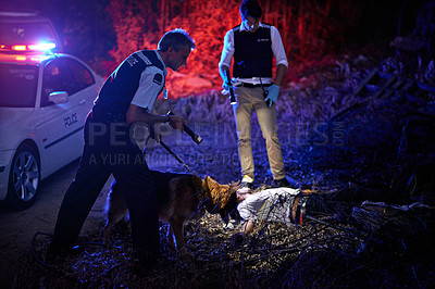 Buy stock photo Shot of policemen inspecting a murder scene at night